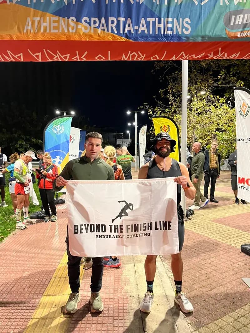 Coach Stefan and BFL athlete Andreas with the Beyond the Finish Line banner at the Athens-Sparta-Athens start line